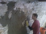 Coating being applied to basement wall for waterproofing